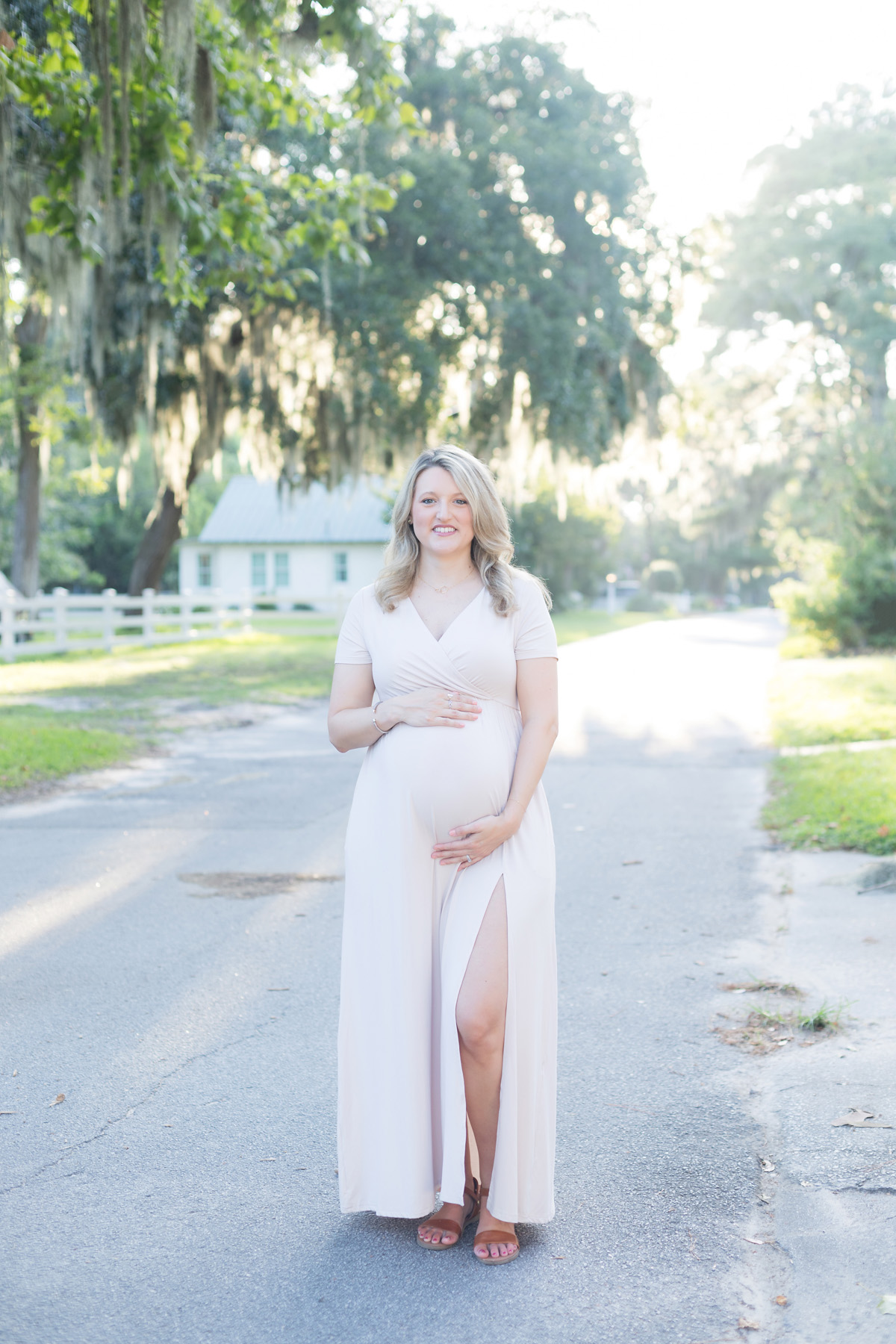 Woman holding baby bump during maternity session in Isle of Hope, Georgia.