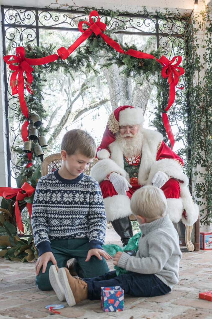 Two brothers opening gifts in front of Santa