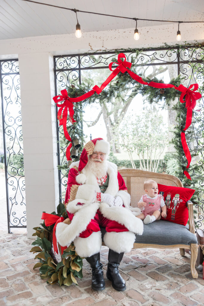 A baby boy starts to cry as Santa is sitting next to him at a holiday set up in Savannah.