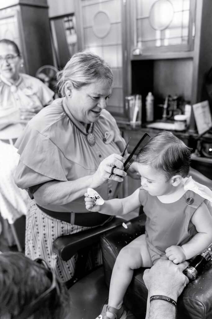 A toddler boy has his haircut in this black and white edited photo taken by his mom, a Savannah Family Photographer. 