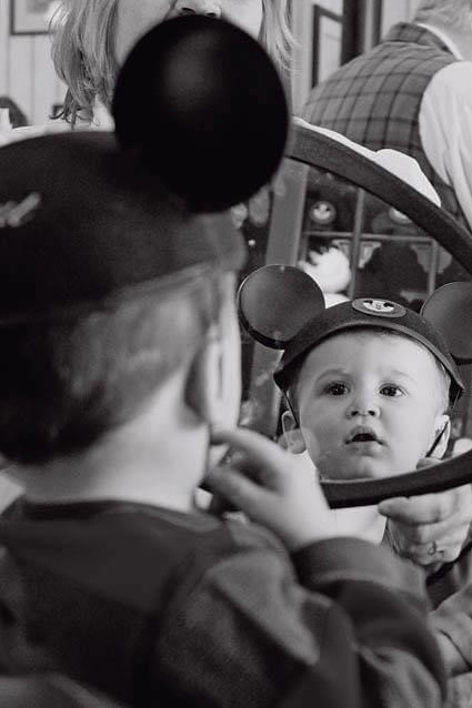 Savannah family photographer, Tiffany Bradley's oldest son looking in a mirror at his first haircut.