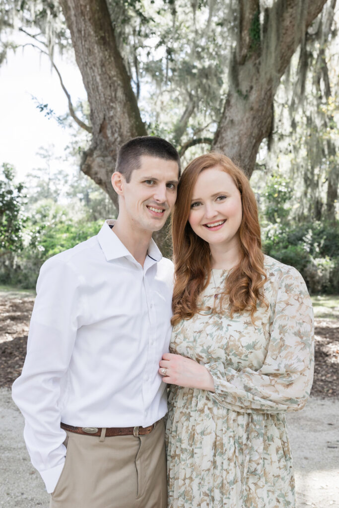 A young couple pose in front of the oak tree where they married in Savannah, Georgia.