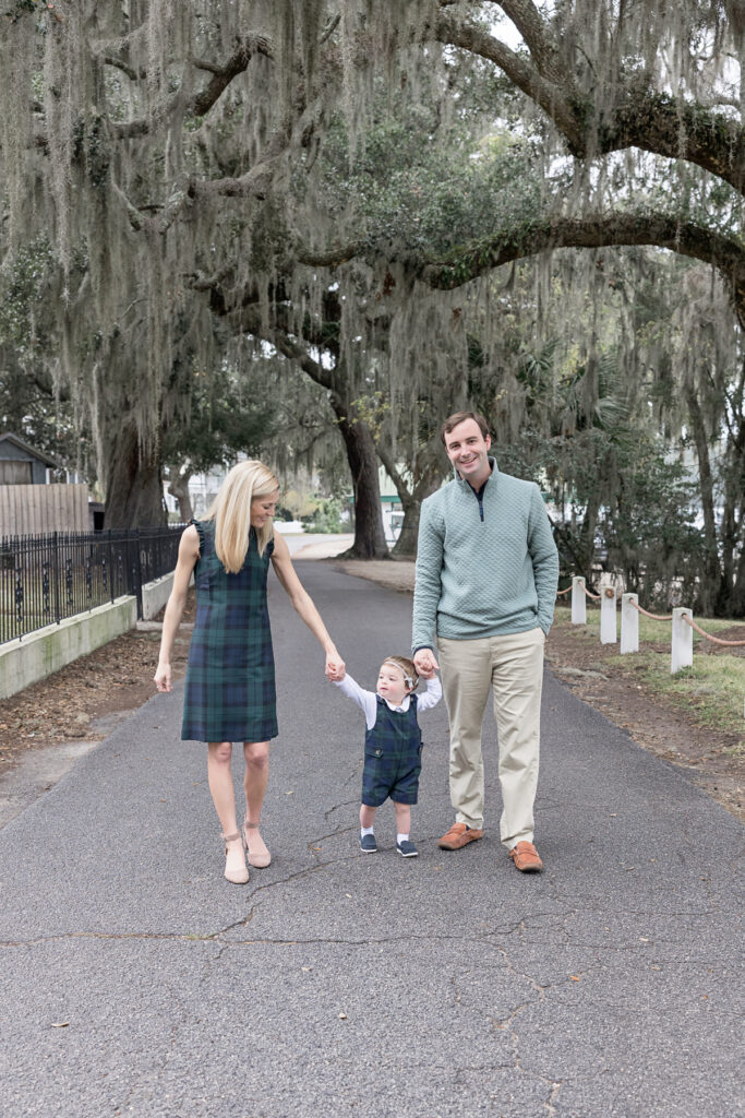 A family walks along Bluff Drive in Isle of Hope during fall in Savannah, Georgia.