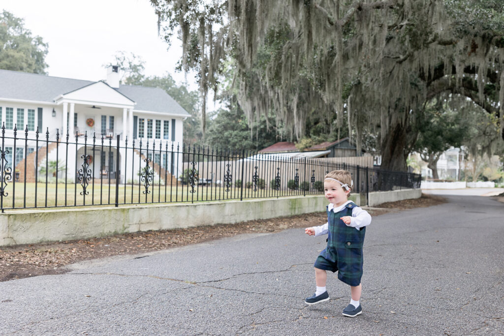 A little boy runs along Bluff Drive, dressed in a Beaufort Bonnet Company plaid jon jon.