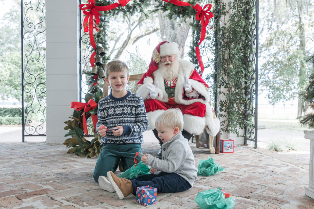 Two boys smile at the custom ornaments they received from Santa.