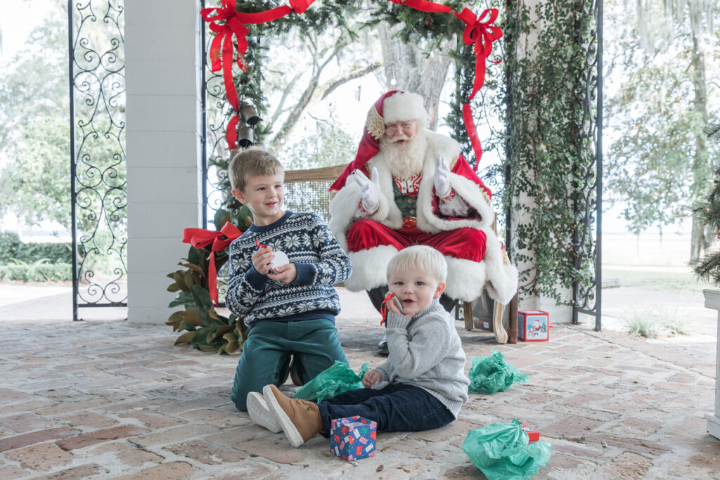 Two boys smile with ornaments they received from Santa at HollyOaks on the Marsh photo sessions with Tiffany Bradley Photography.