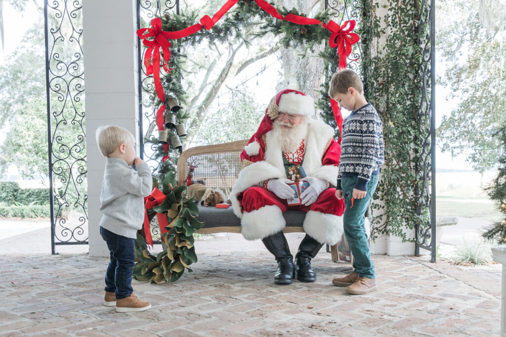 The yougest of the two brothers gets braver and comes closer to Santa during his portrait session.