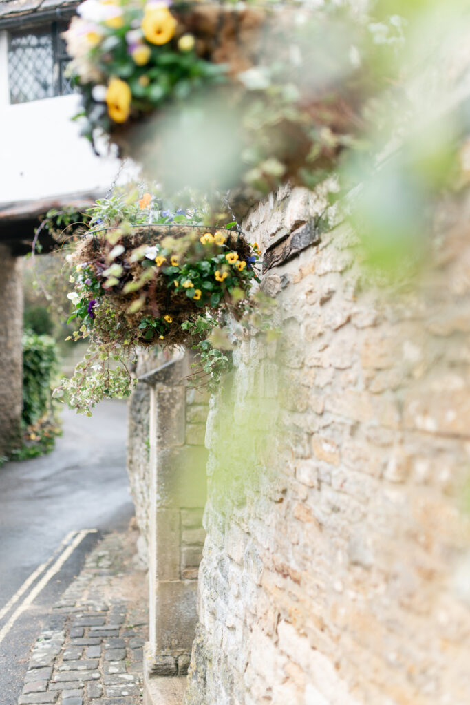 Hanging baskets along a stone wall