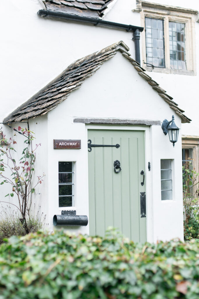 Green door on the front of an old white stone building