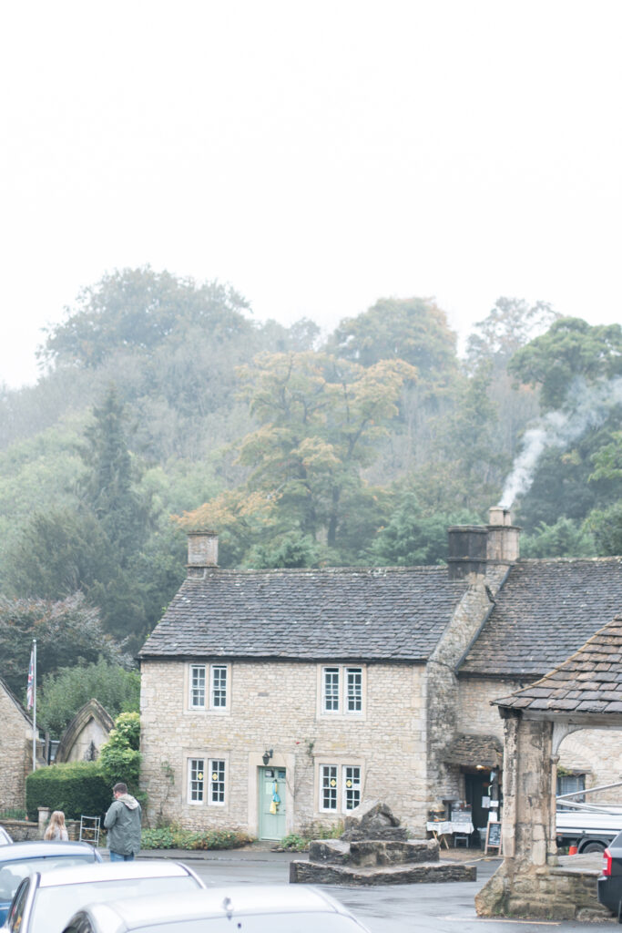 An old stone building with smoke coming out of the chimney.