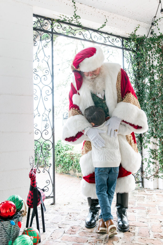 A young boy hugs Santa in the veranda at HollyOaks on the Marsh.