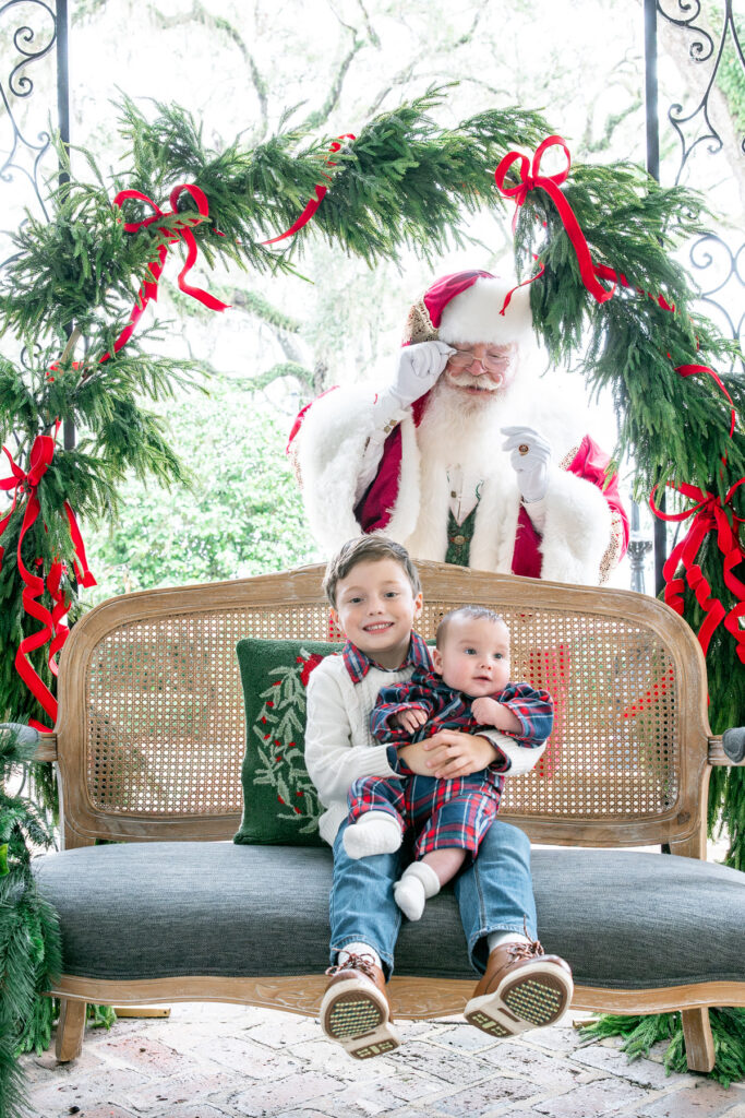 Santa peeks at two boys who are waiting on him at HollyOaks on the Marsh.