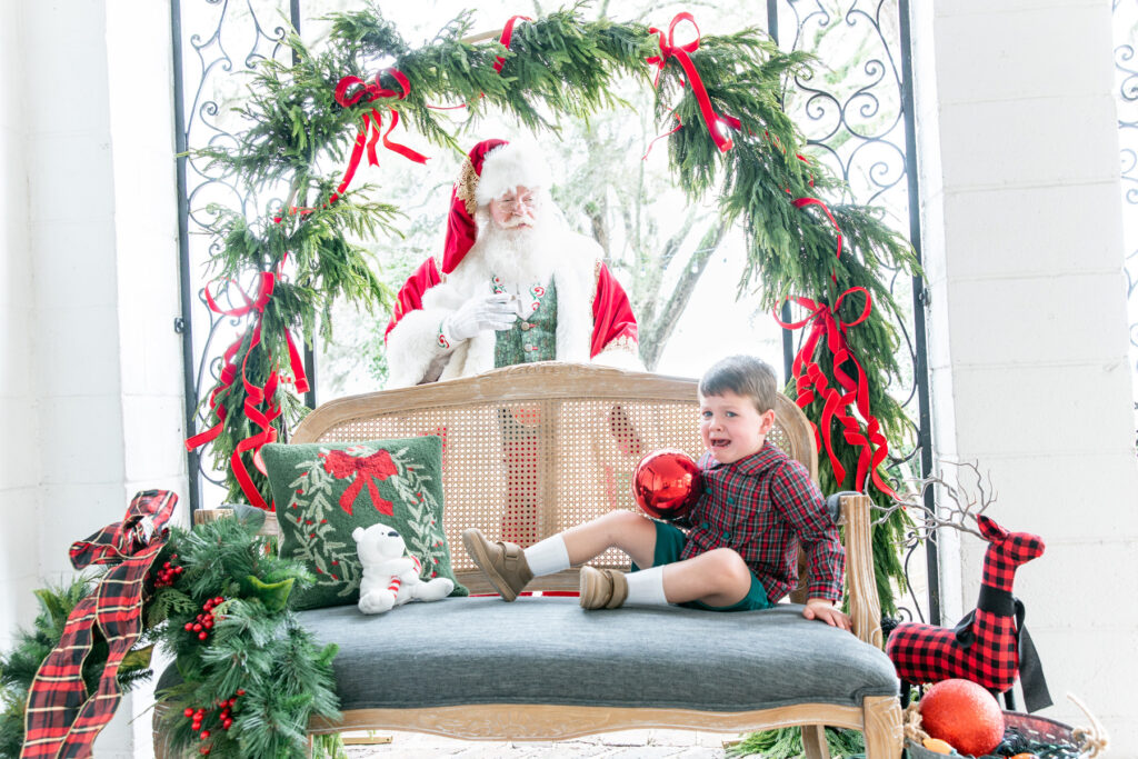 Little boy on bench crying with Santa behind him