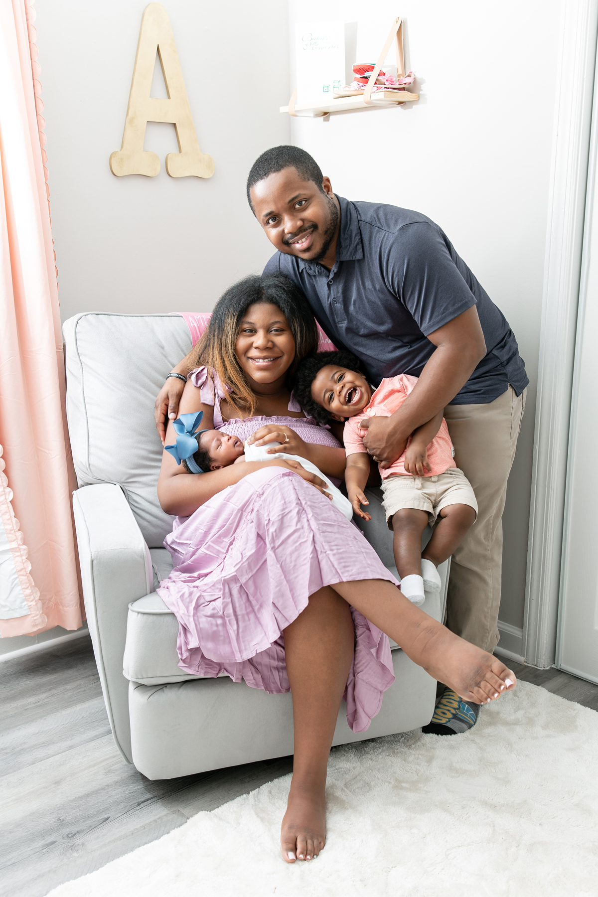 A new family of four poses for their Savannah newborn photography session at their home.