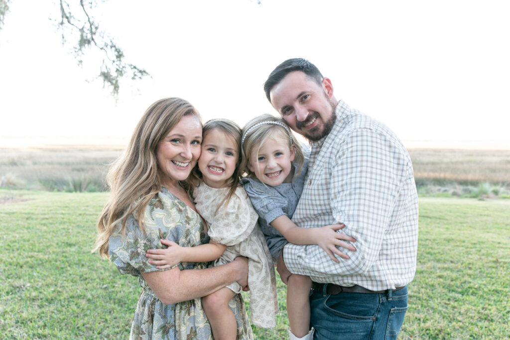 A family of four, photographed in front of the marsh in Savannah, Georgia.