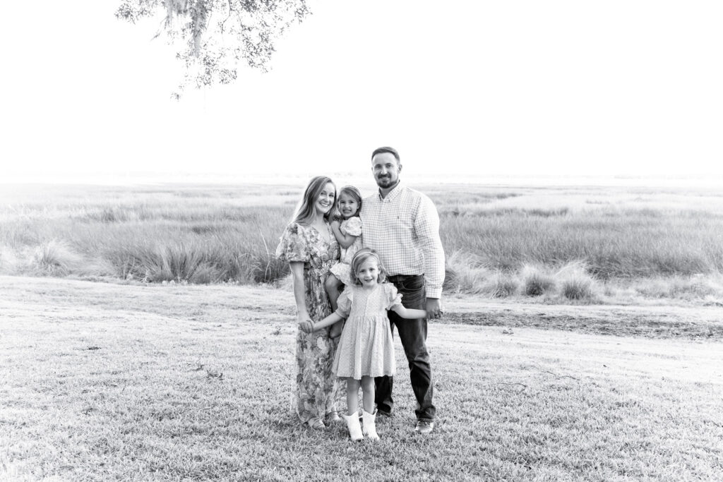 A family of four photographed in front of the marsh in Savannah, Georgia.