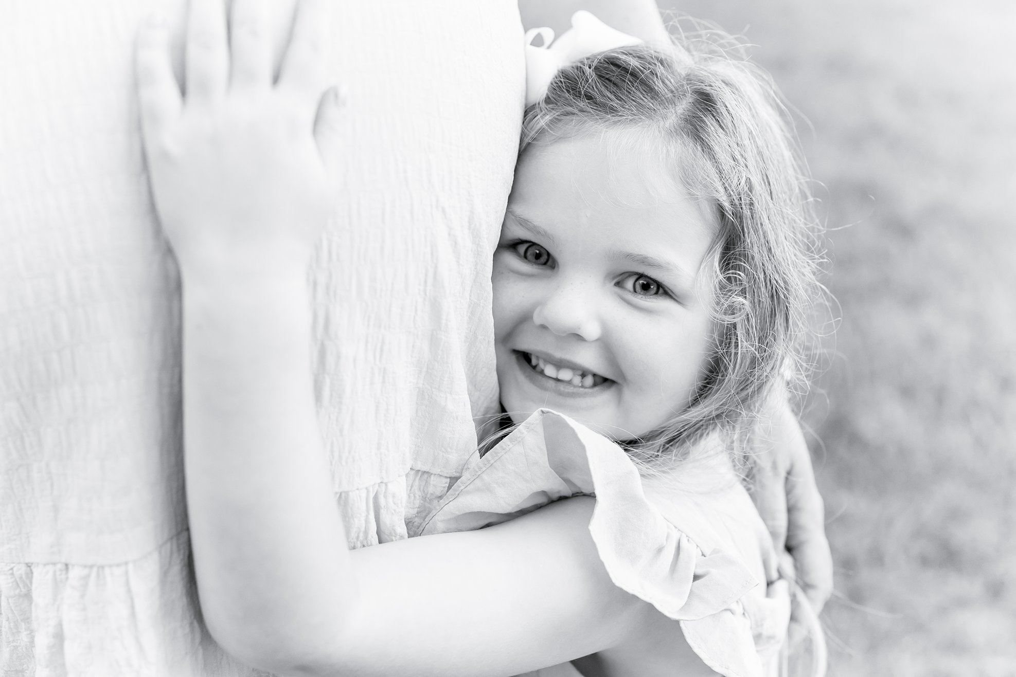 a family maternity photography savannah ga session with the daughter hugging mama and baby