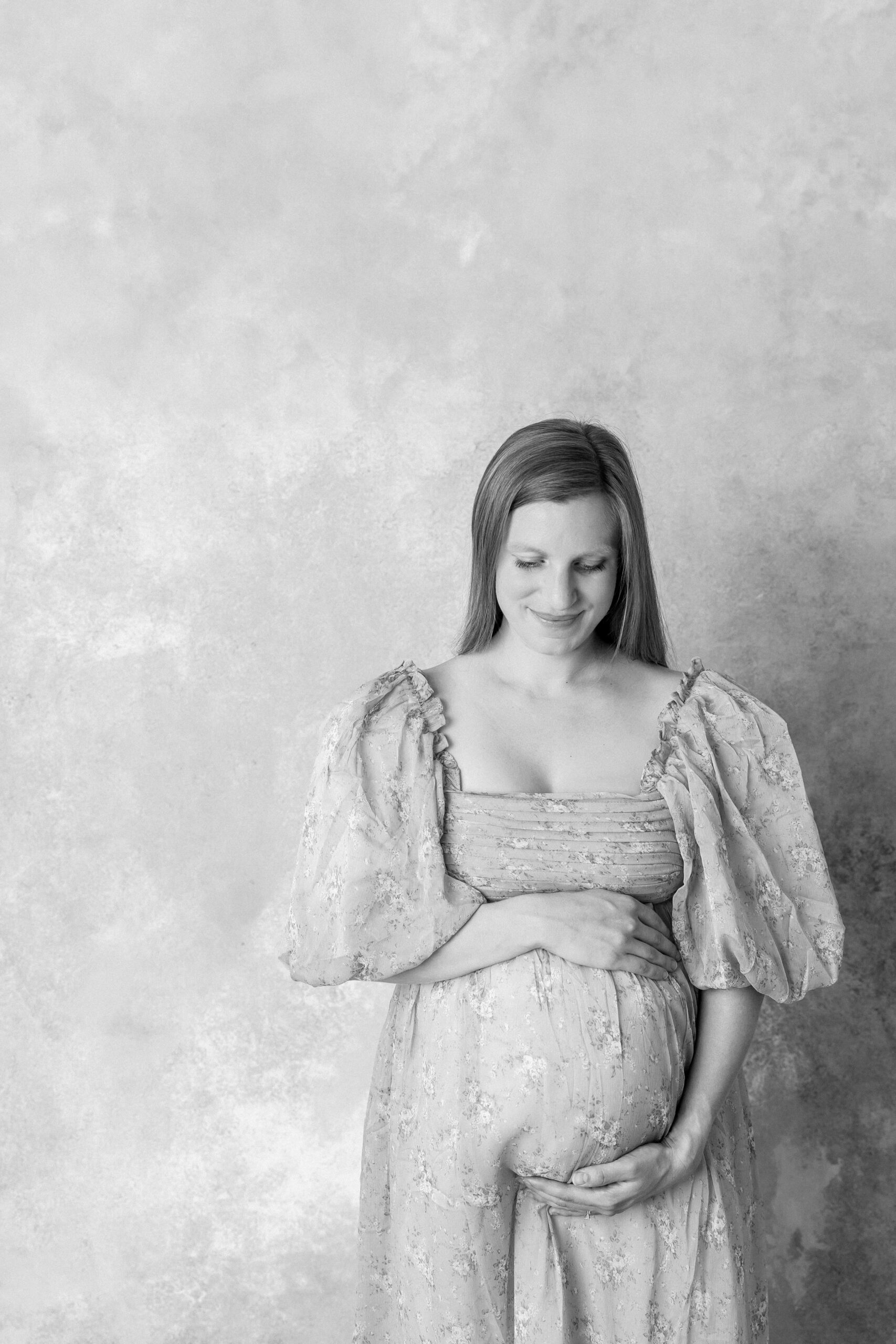 Mother smiling and showing what to wear to your maternity photoshoot
