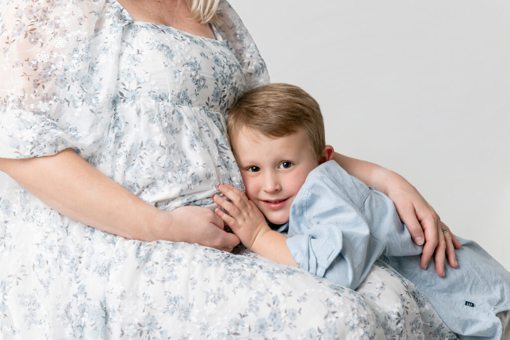 A young boy hugs his mom's pregnant belly. Maternity pictures Savannah.