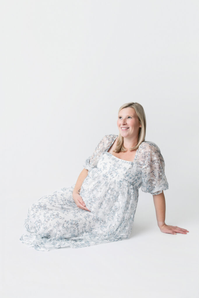 Savannah, GA Maternity session with an expectant mother sitting on the ground, cradling her belly.