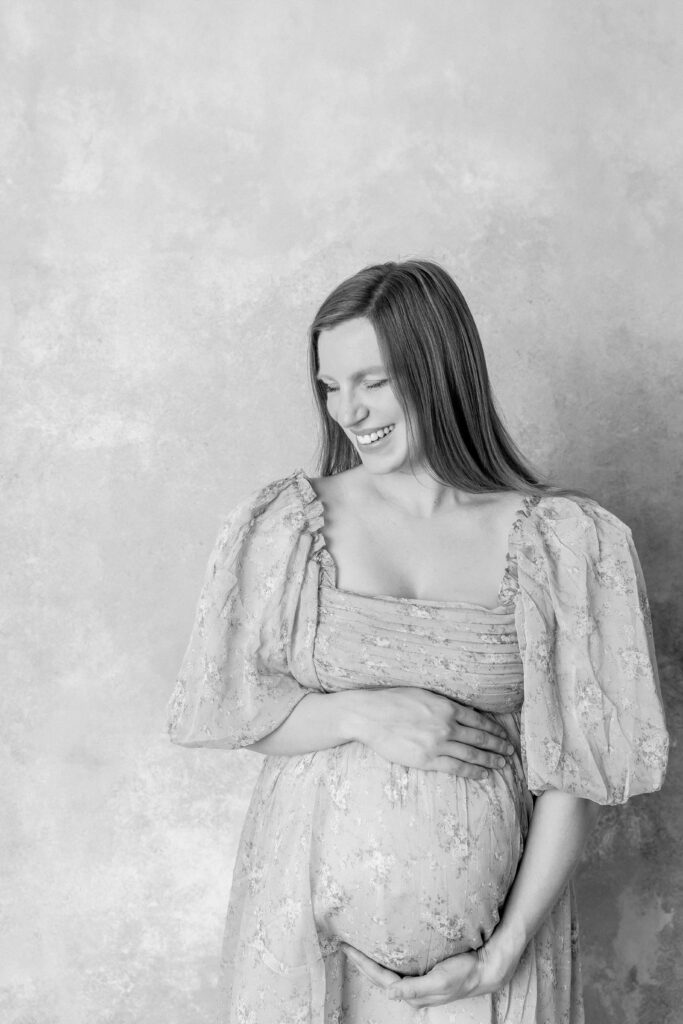 Smiling mother showing What to Wear to Your Maternity Photoshoot