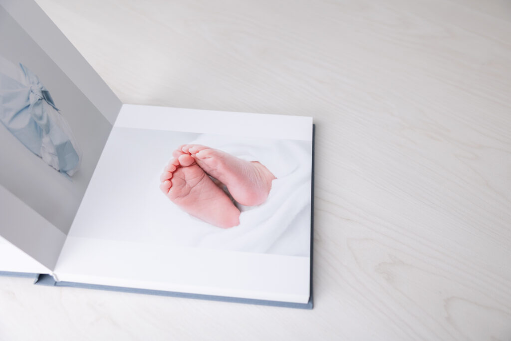 A close up of an album page with baby feet from a newborn photography session in Savannah, GA.