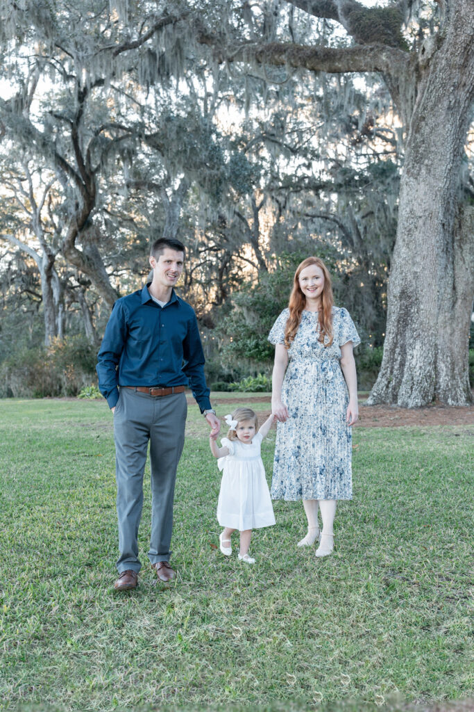 Family of three dressed in blues and whites during a fall session at HollyOaks on the Marsh with Tiffany Bradley Photography.