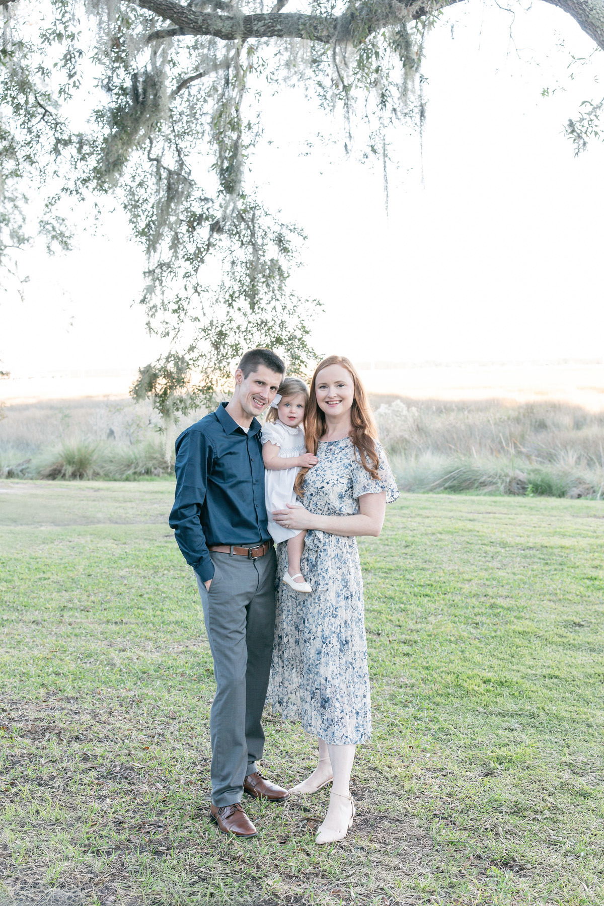 Family dressed in blue and white during a fall photo session overlooking the marsh in Savannah, GA.