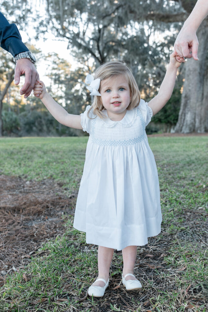 Close up of toddler girl holding her parents hands from family session with Savannah, GA photographer Tiffany Bradley Photography 