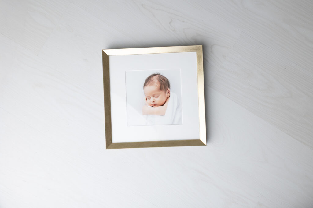 A gold framed portrait of a newborn baby boy by Savannah photographer Tiffany Bradley.