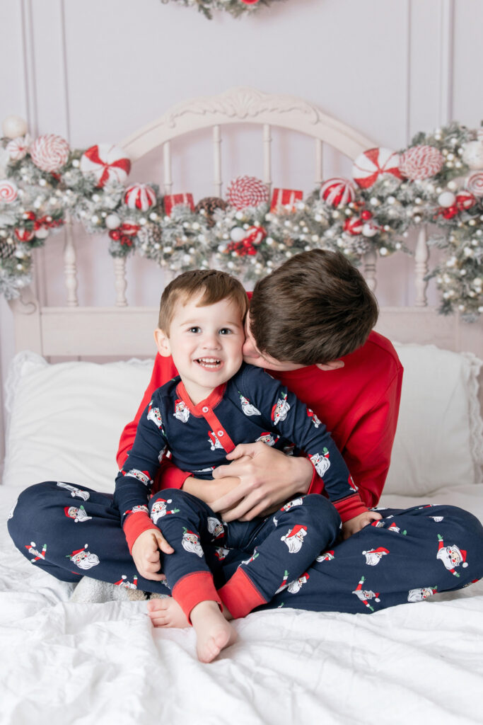 Two brothers, dressed in matching Santa pajamas from Littles on Liberty, a Beaufort Bonnet Signature Store, during a Christmas portrait session in Savannah, Georgia with Tiffany Bradley Photography.