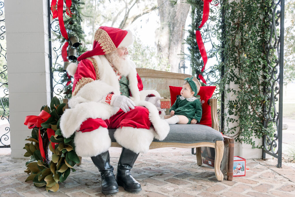 Santa portraits at HollyOaks on the Marsh in Savannah, GA featuring a baby girl in a classic holiday dress.