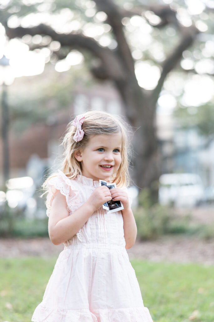 Big sister to be holds an ultrasound during maternity pictures Savannah, GA