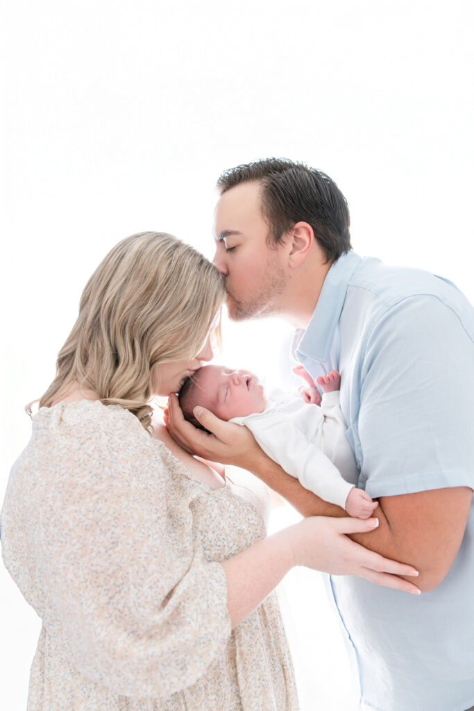 Gallery of newborn photography in Savannah, GA featuring a baby boy, parent portraits, family images, and white and fine art newborn backgrounds in a studio setting.