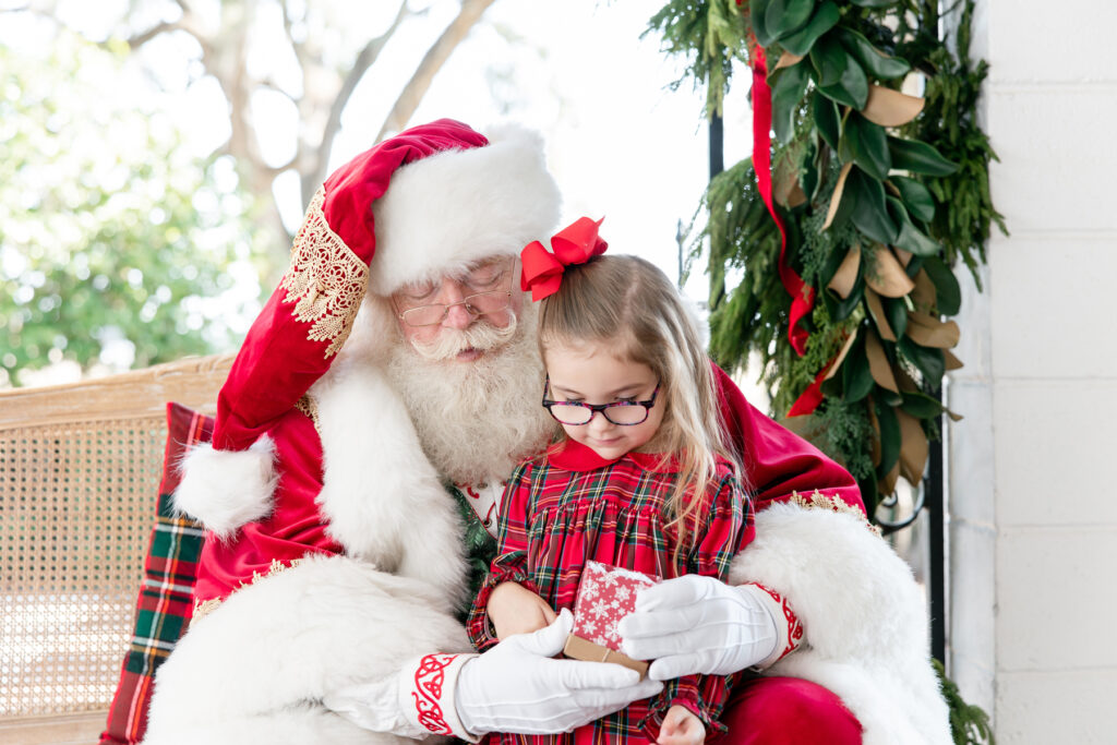A little girl opens a gift during her Santa session at HollyOaks on the Marsh in Savannah, GA.