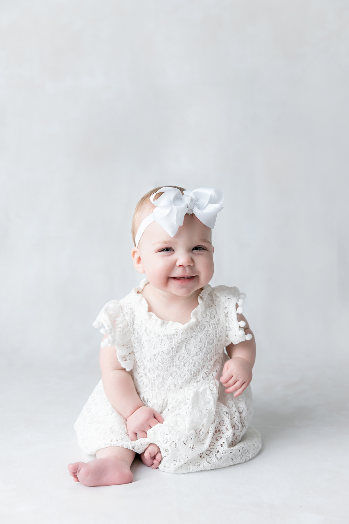 A baby girl smiles during her 6 month baby milestone session in Savannah.