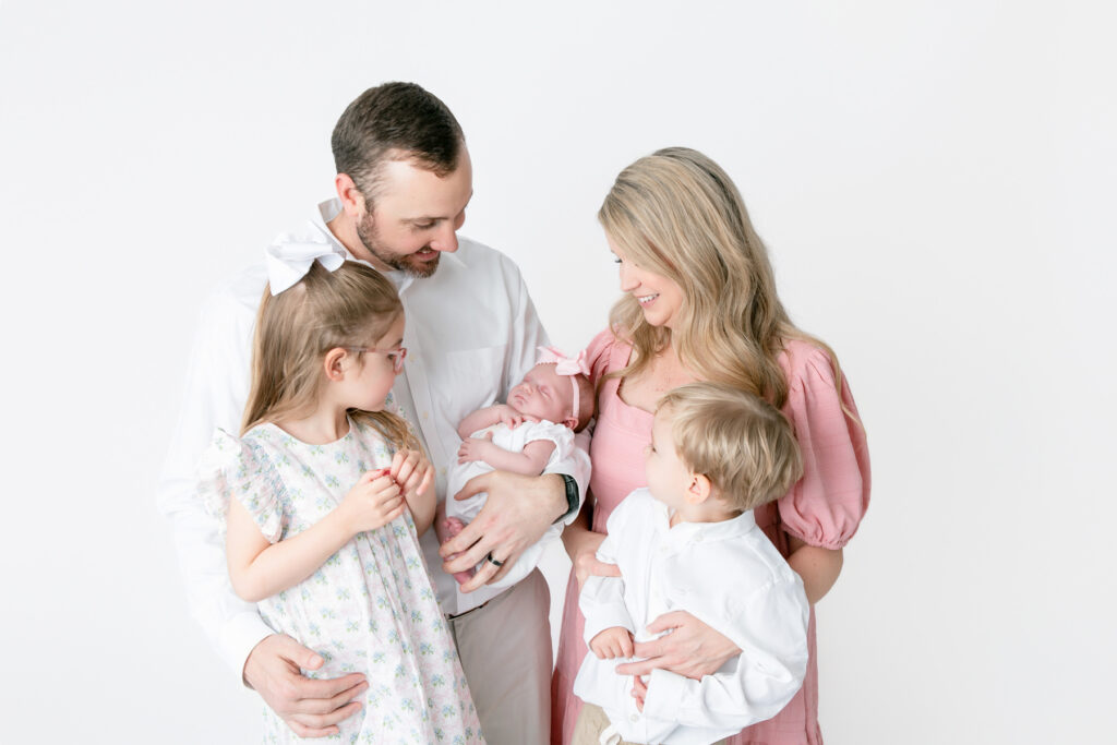 family portrait with parents, siblings, and newborn baby in Savannah GA photography studio