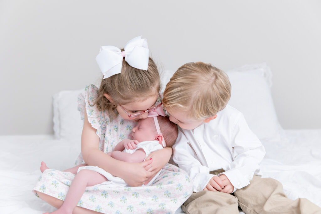 older siblings kissing newborn baby during Savannah newborn session