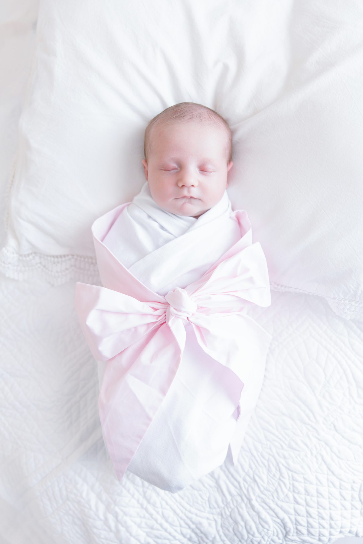 newborn baby wrapped in a bow swaddle during studio session in Savannah GA