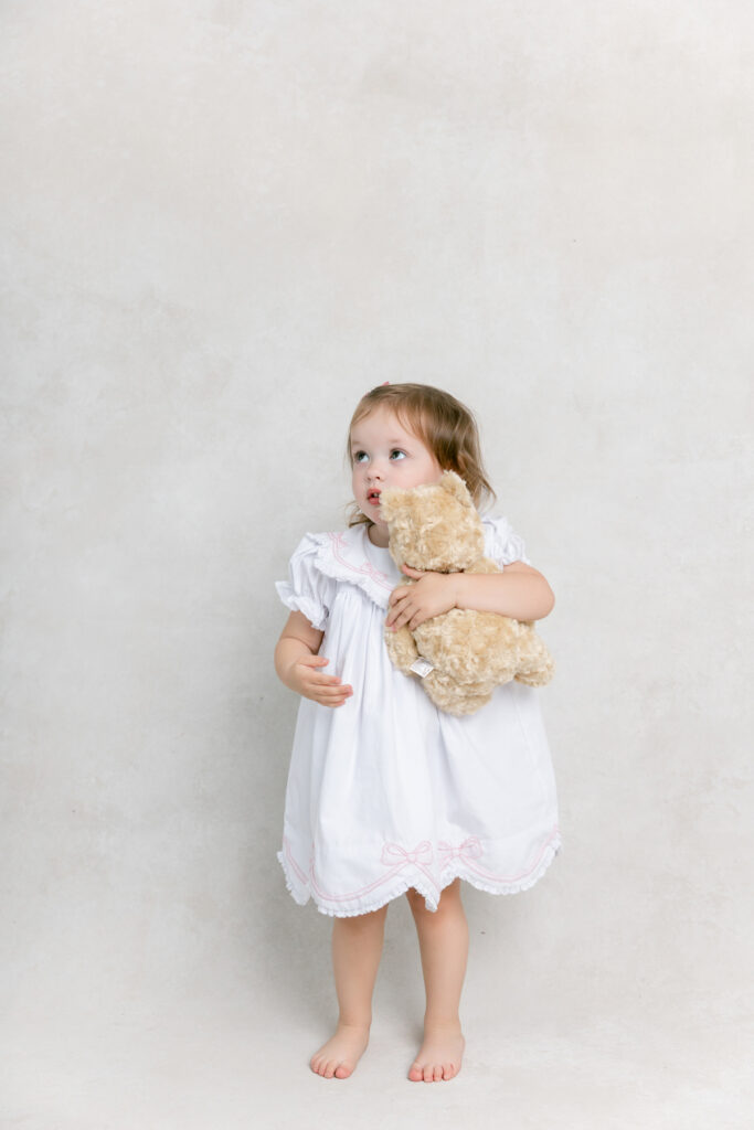 Little girl with bear stuffy at studio newborn session in Savannah.