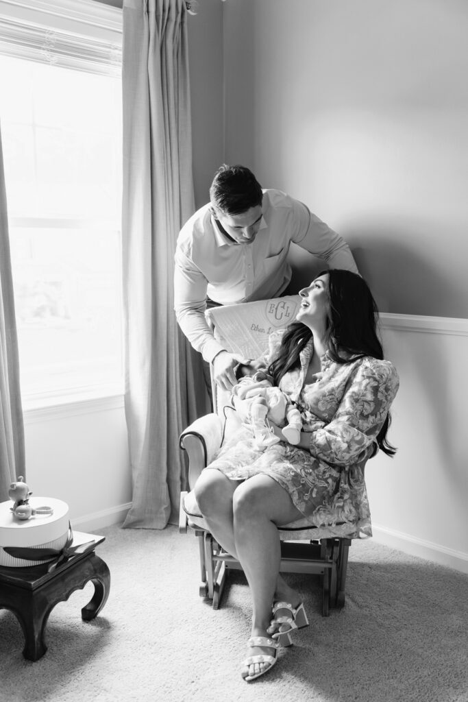 Black and white images of parents in rocking chair in newborn baby's nursery in Savannah, GA.