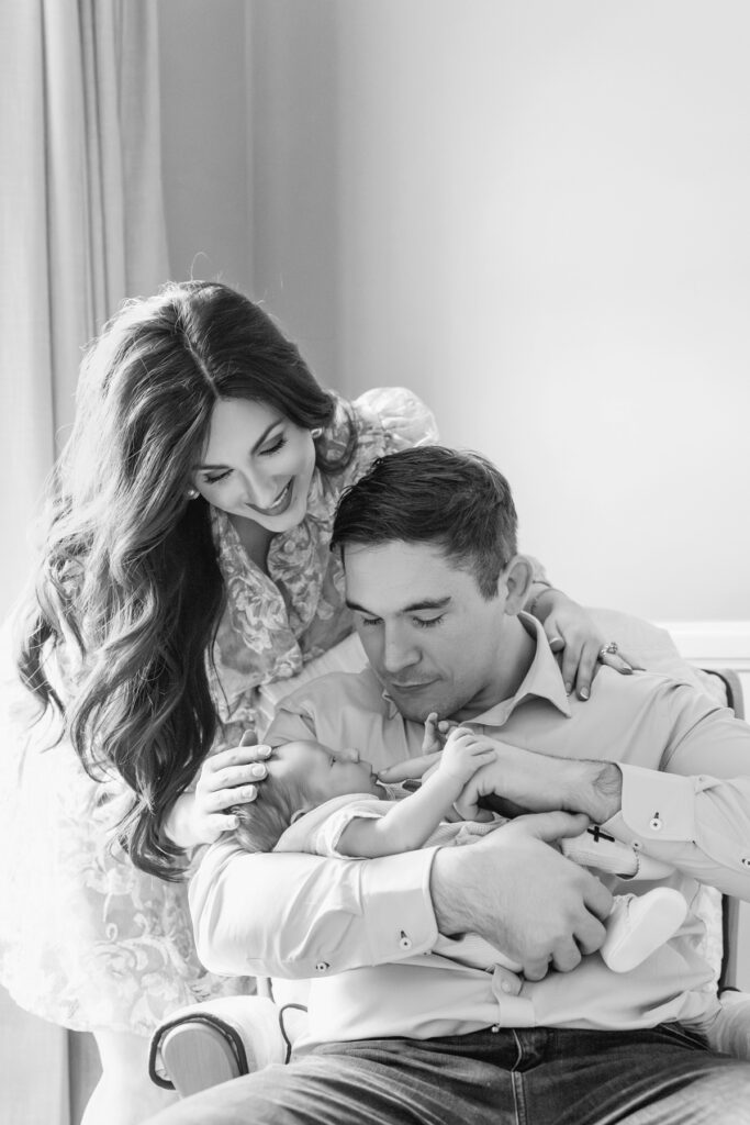 Black and white images of parents in rocking chair in newborn baby's nursery in Savannah, GA.