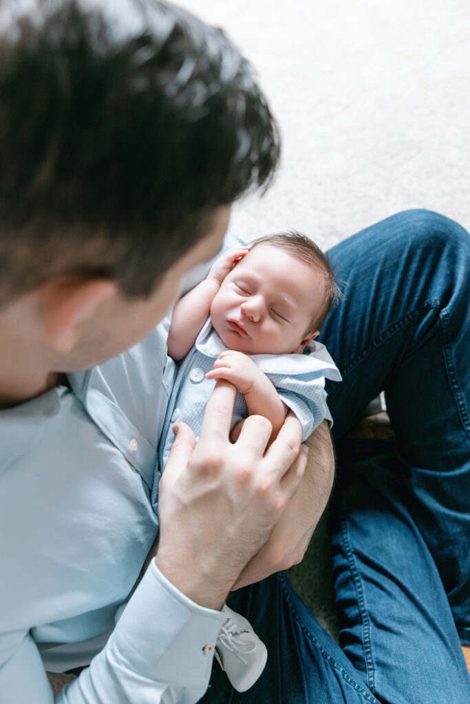 Close up photos of mom and dad each holding their new baby at an in home newborn session.