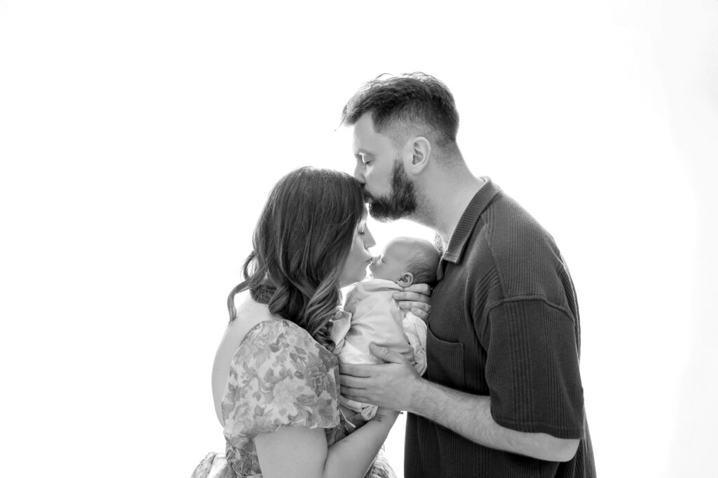 Backlit, black and white parent shot during a new baby photo session.