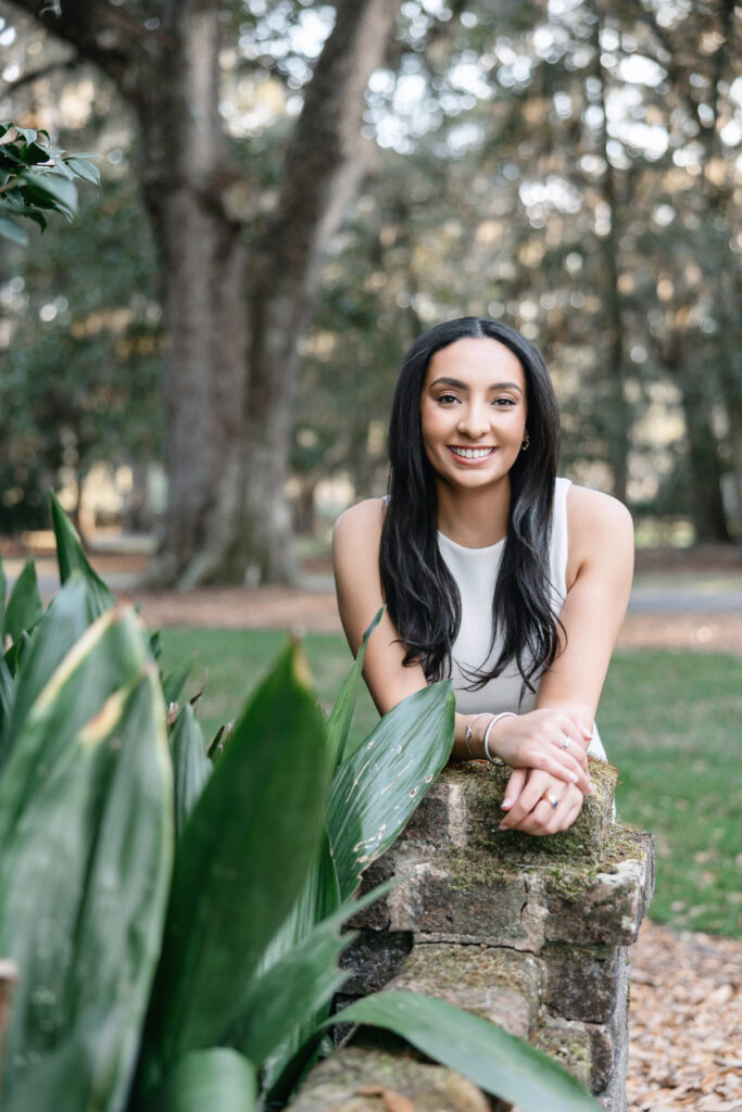 College graduate in white dress during senior session with Tiffany Bradley Photography
