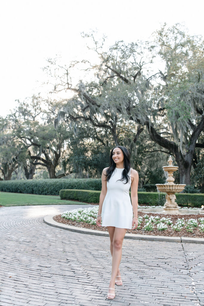 Senior pictures in Richmond Hill, GA featuring a college graduate in a white dress
