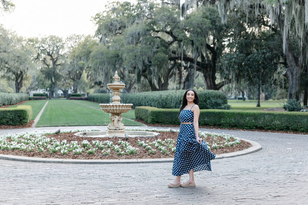Female college senior posing near fountain in Richmond Hill, GA