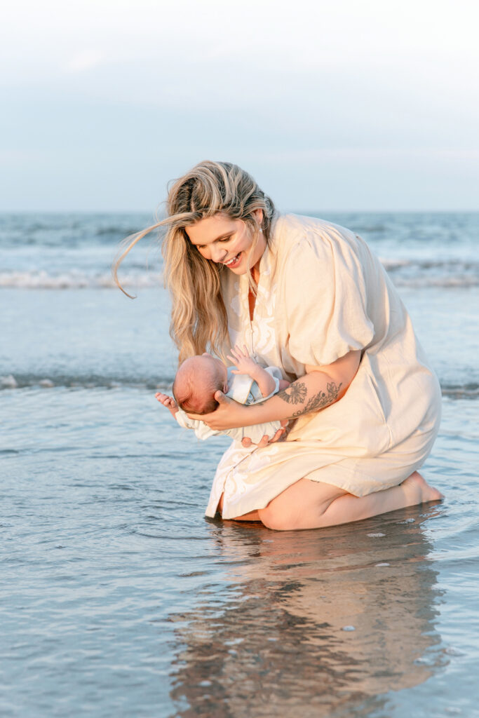 A mom with each of her children in the water at Tybee Island for a lifestyle newborn session.