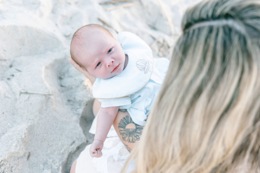 An overhead shot of a newborn held by his mom at Tybee Island