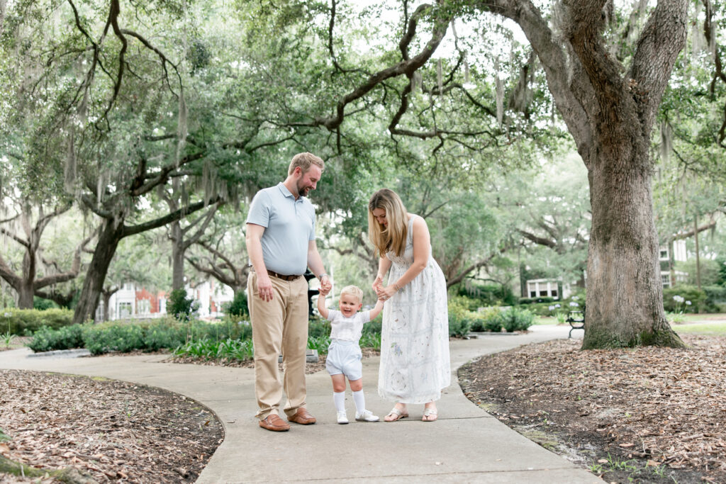 Parents holding hands with their son in a Savannah park